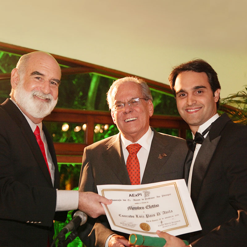 Das mãos dos doutores Carlos Alberto Jaimovich e Liacyr Ribeiro, Conrado DAvila recebe seu certificado de Membro Efetivo da Associação dos Ex-alunos do Prof. Ivo Pitanguy